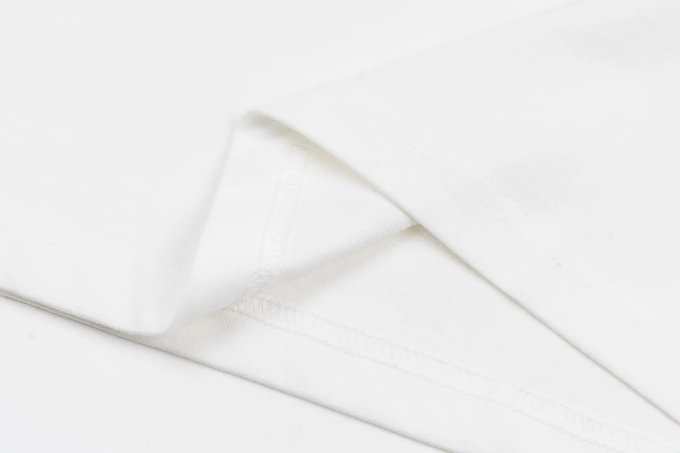 🅿️300 1v SKI ski series velvet jacquard foam short sleeves. The fabric is made of 15S 230g fine cotton plain fabric, and the rib is made of 32S 380g double yarn rib. This T-shirt is made of elegant cotton with a richly textured velvet 1V pattern on the front, depicting rock peaks, snowfields and forest scenes. The crack effect simulates a forest path, and the 1V logo is implicitly embellished in the center. The avant-garde and elegant shape embodies the casual style of winter. The base is made of 15-count combed cotton jersey fabric, with a weight of 230g/㎡, giving it a flexible texture and excellent morphological stability. Short lint impurities are removed through the combing process to ensure the smoothness of the cloth surface and yarn strength. Combined with high-density weaving, the fabric has a delicate and smooth texture, providing an ideal canvas for subsequent complex printing. The surface of the fabric is smooth and delicate, and the texture is tight. The fabric has good softness and comfort, stable breathability, and can keep the body dry. The pattern is realized through overprinting of more than six colors of velvet slurry. In the gradient transition between rock peaks, snowfields and forests, by adjusting the density of velvet powder and the thickness of the slurry, a micro-three-dimensional suede surface drop of 0.2-0.5mm is formed. The snow peak area uses high-reflective velvet pulp to create a cold texture, and the forest part uses dark thick slurry accumulation to simulate vegetation levels. The crack effect uses the slurry blanking technique to tear out a visual channel to the base fabric in the suede matrix. Size:XS-S-M-L
